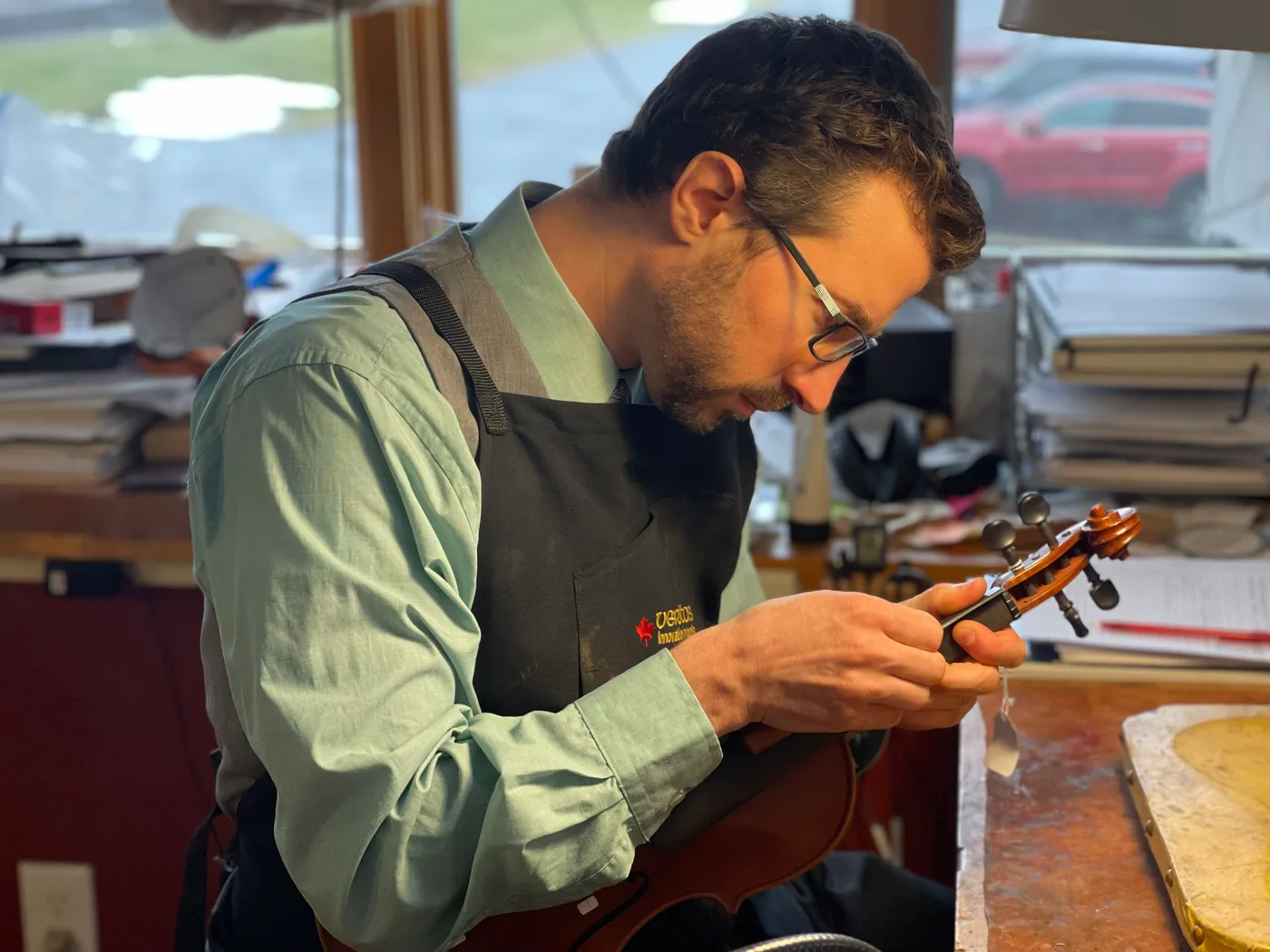 Robert Johnson working on the pegbox of a violin at the bench.