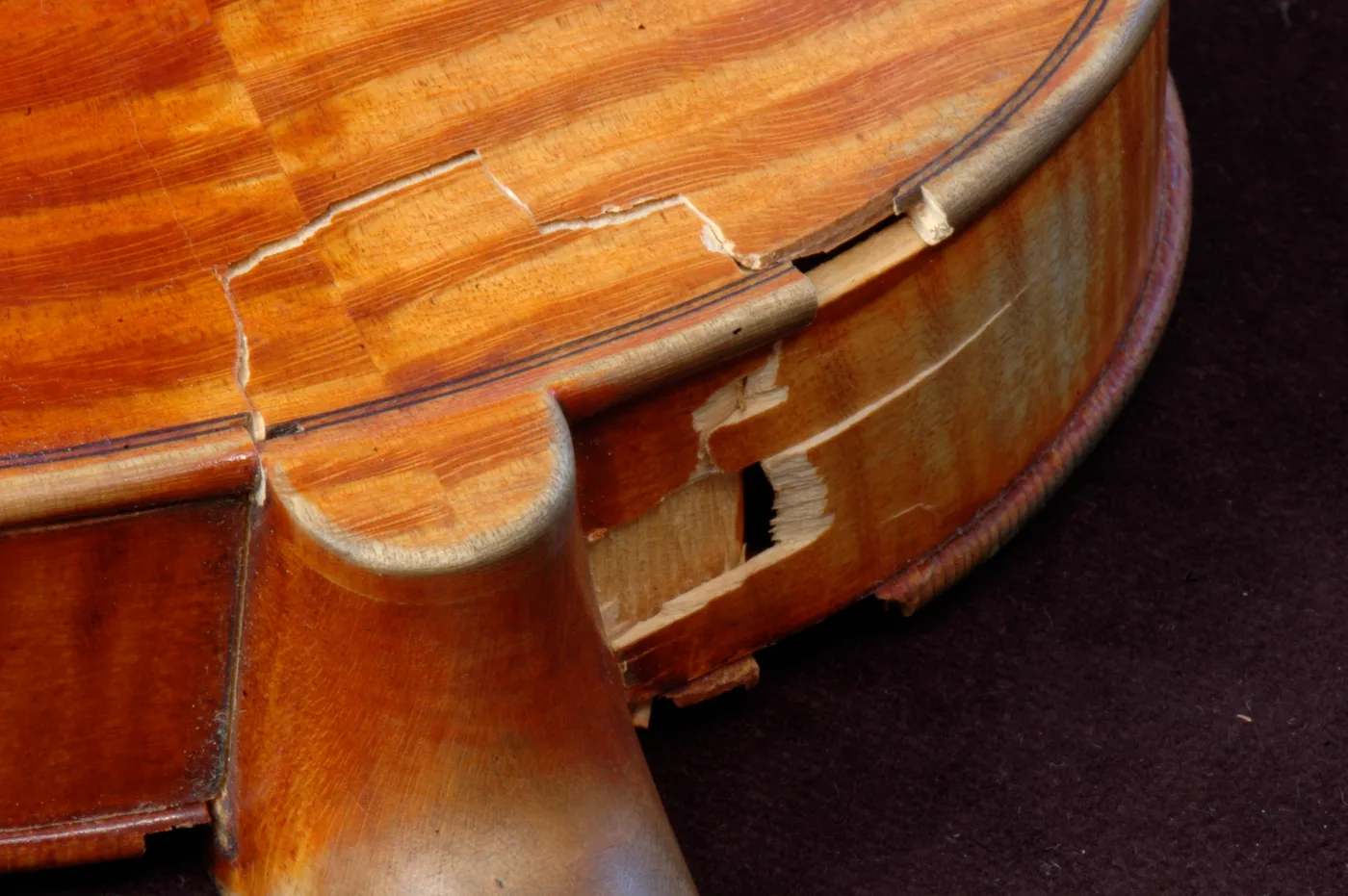 A cracked lower bout near the neck heel, mid-restoration.